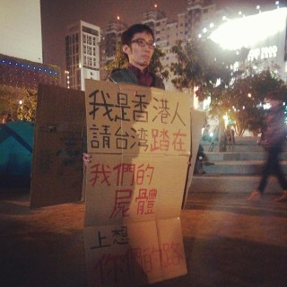 A resident of Hong Kong supports the Sunflower Movement, holding a sign that says, "I am from Hong Kong. People of Taiwan, please step on our corpses as you think about what path you will take forward."